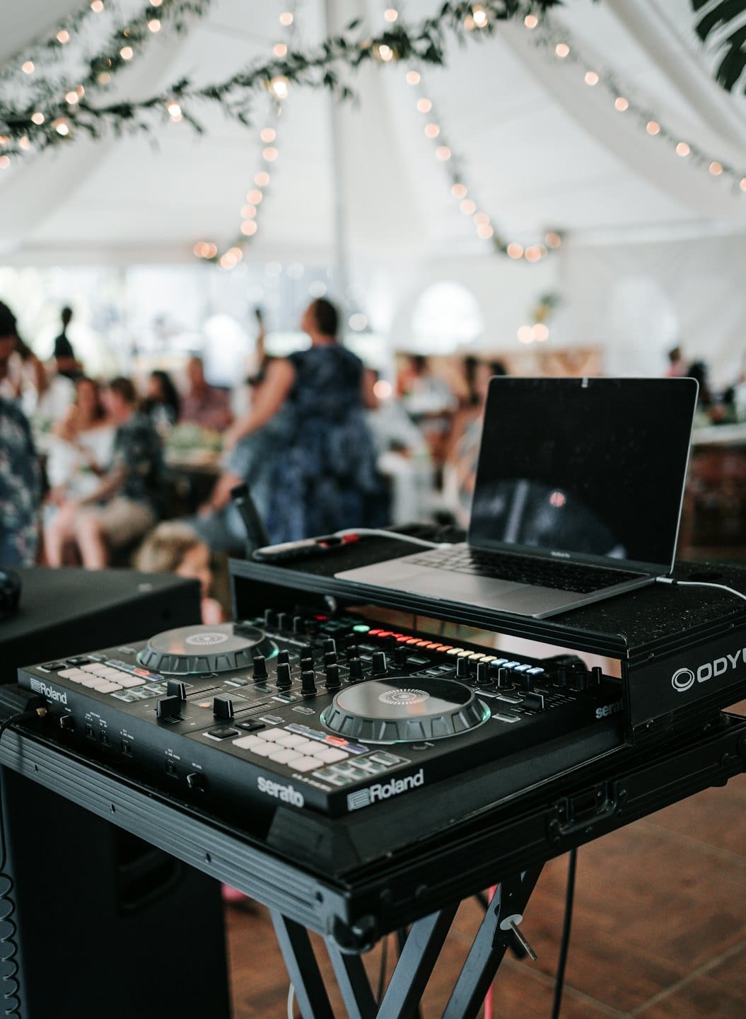 DJ-Mischpult und Laptop unter einem großen weißen Festzelt.